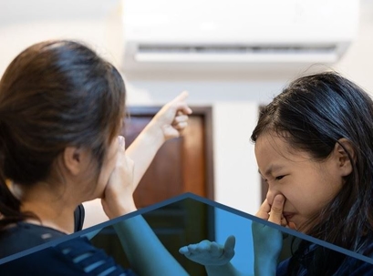 Two women smelling something funky from AC