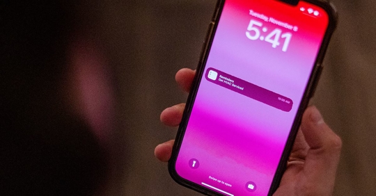 hand holding phone with HVAC service reminder on the display